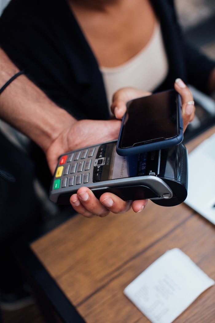 A smartphone is used for a contactless payment on a wireless terminal indoors.